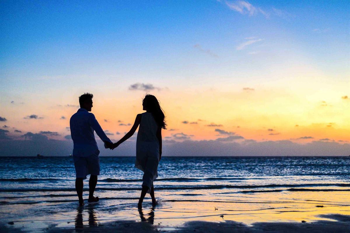 A couple holding hands at sunset