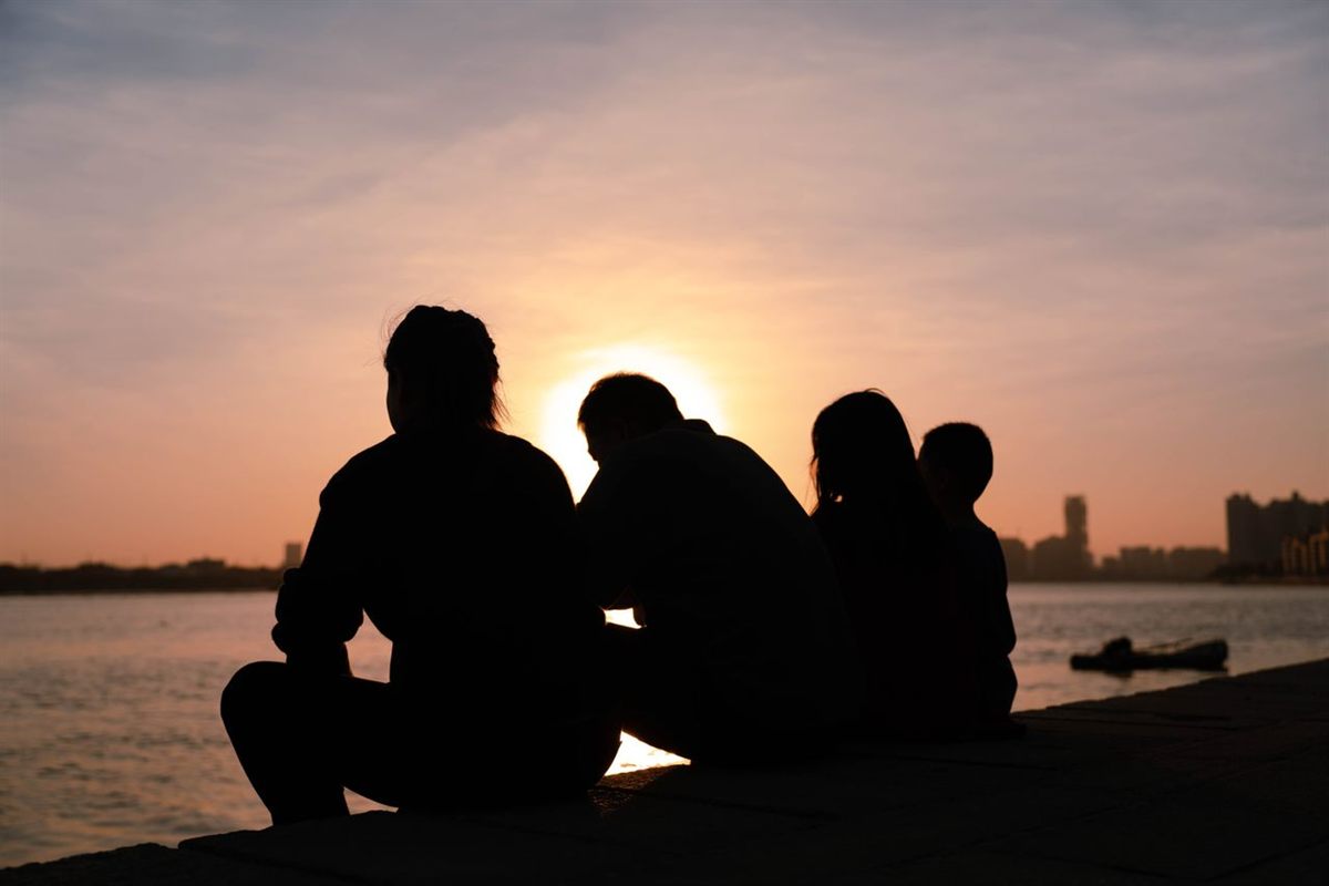 A family together at sunset by the water