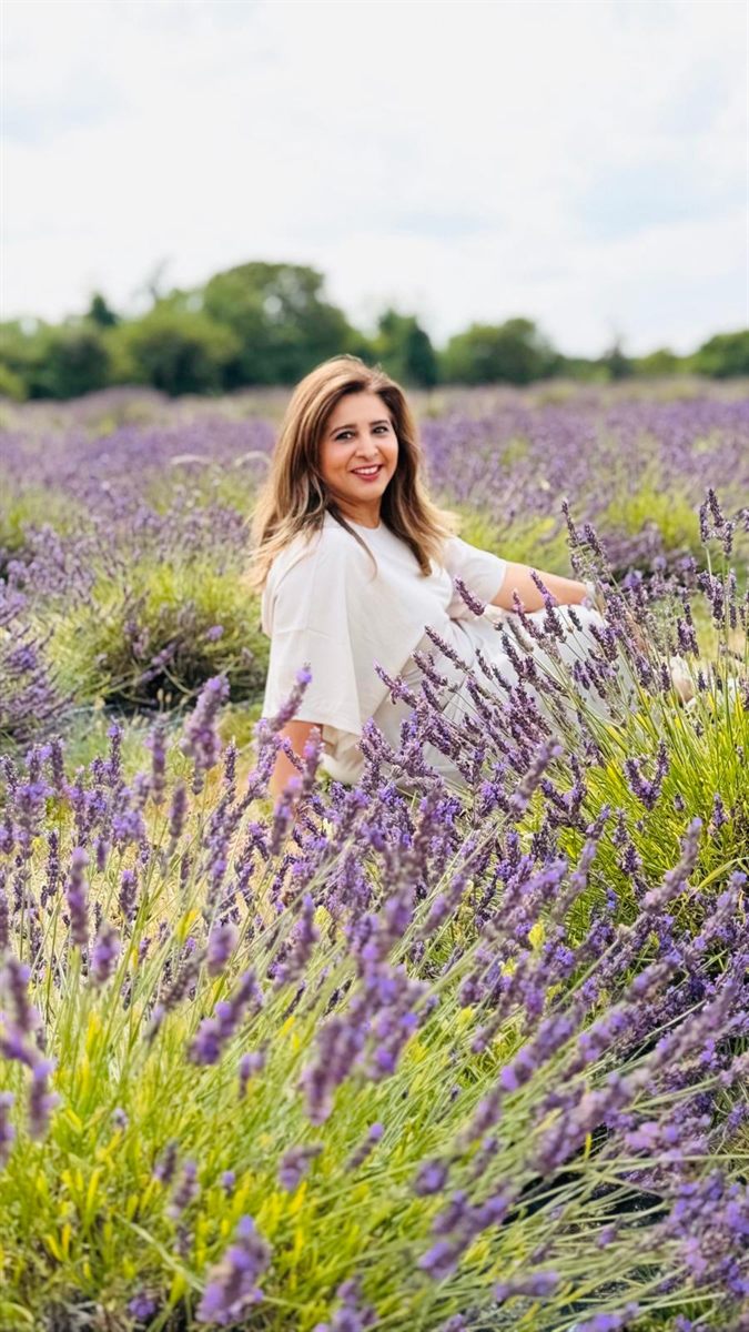 Huma, integrative psychotherapist, sitting in a lavender field